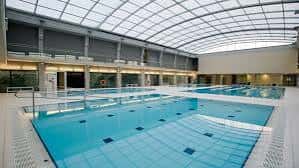 Piscina interior del centro deportivo con cubierta acristalada y zonas de natación