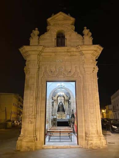 Vista nocturna de la fachada iluminada de la Capilla de la Yedra