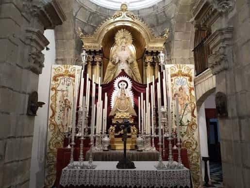 Interior del altar principal con retablo dorado y escultura religiosa