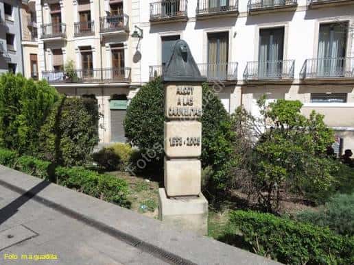Monumento conmemorativo en la Placeta del Fossar con fachadas de edificios residenciales al fondo
