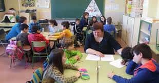 Clase en el interior del colegio con alumnos y profesora