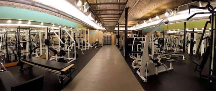 Sala de musculación con máquinas de peso libre y espejos en el Castle Hill Fitness