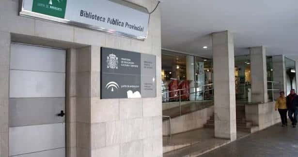 Entrada principal con señalización institucional y acceso a la biblioteca