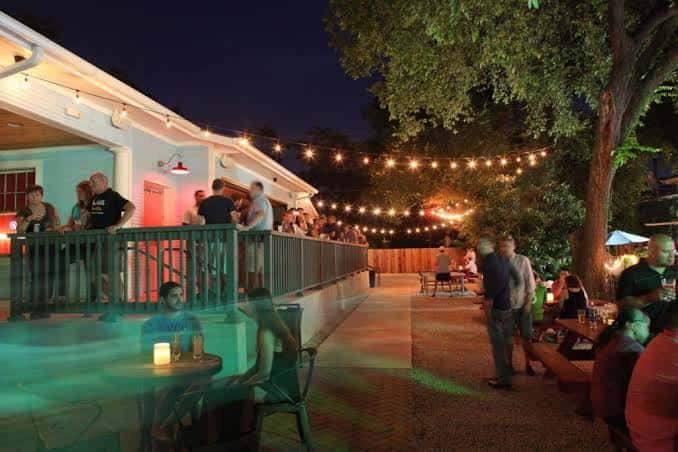 Terraza superior del bar durante la noche con vista a la zona de eventos