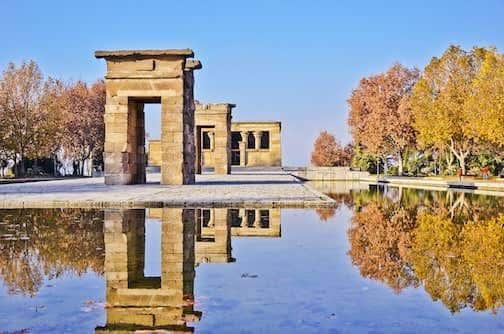 Templo de Debod en otoño con árboles de colores y reflejo en el agua