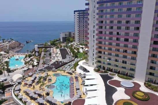 Vista aérea del complejo hotelero con múltiples piscinas, zonas de descanso y acceso directo al mar