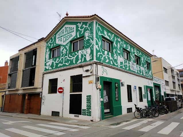 Fachada del edificio Can Capablanca con murales verdes y blancos
