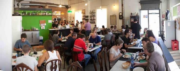 Interior del restaurante lleno de comensales en mesas largas
