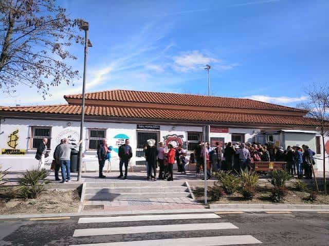 Vista exterior del edificio con personas reunidas frente a la entrada