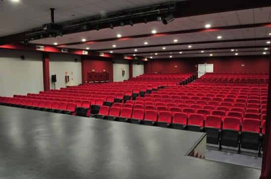 Interior del Teatro Salesianos Estrecho con butacas rojas y escenario vacío
