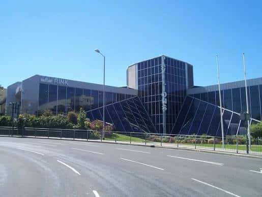 Vista exterior del Plymouth Pavilions con fachada de cristal y estructura moderna bajo cielo despejado
