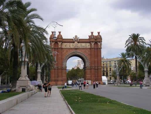 Arco del Triunfo de Barcelona con palmeras y peatones