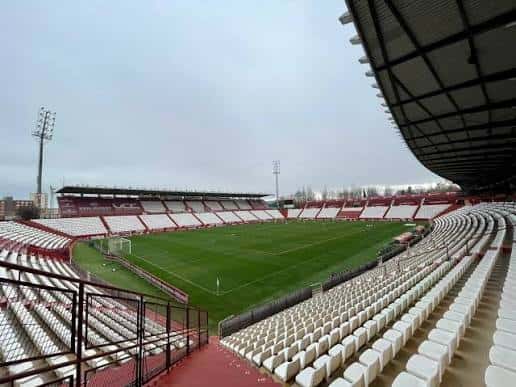 Vista panorámica del interior del Estadio Carlos Belmonte con gradas vacías y campo de juego