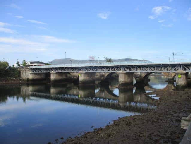 Vista panorámica del Puente Internacional Avenida reflejado en el río Bidasoa bajo un cielo azul