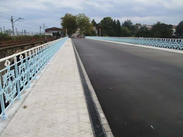 Camino peatonal del puente con barandillas azules y pavimento moderno