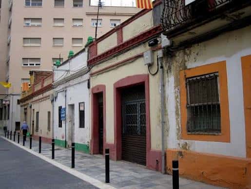 Fachadas tradicionales del barrio con detalles arquitectónicos y banderas catalanas
