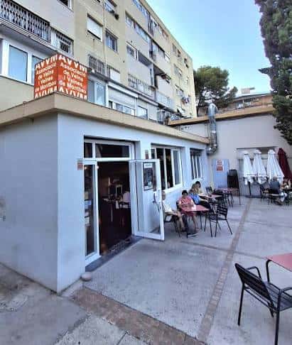 Vista exterior de la Associació de Veïns de Montbau con terraza y mesas al aire libre
