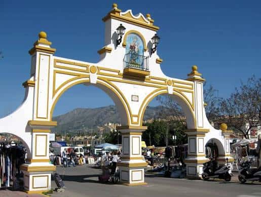 Detalle del arco decorativo en la entrada del recinto ferial bajo cielo despejado