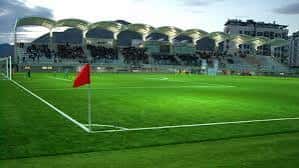 Vista panorámica del campo de juego con gradas y techo ondulado característico