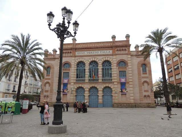 Vista frontal del Gran Teatro Falla en la Plaza Fragela con palmeras y farola clásica