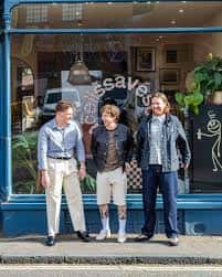 Tres hombres posando frente a la fachada azul de Save Some Brain Cells en Brighton