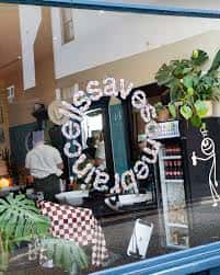 Vista desde la calle del interior del barbershop con cliente y peluquero trabajando
