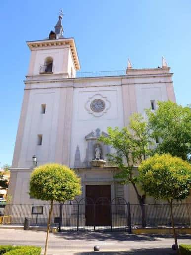Fachada principal de la Iglesia de San Esteban Protomártir con torre y jardín frontal