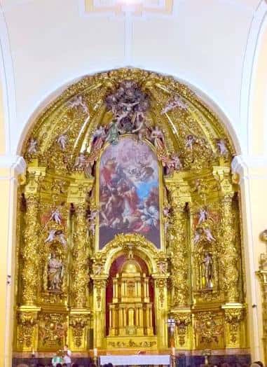 Vista interior del altar principal con decoración en oro y detalles escultóricos