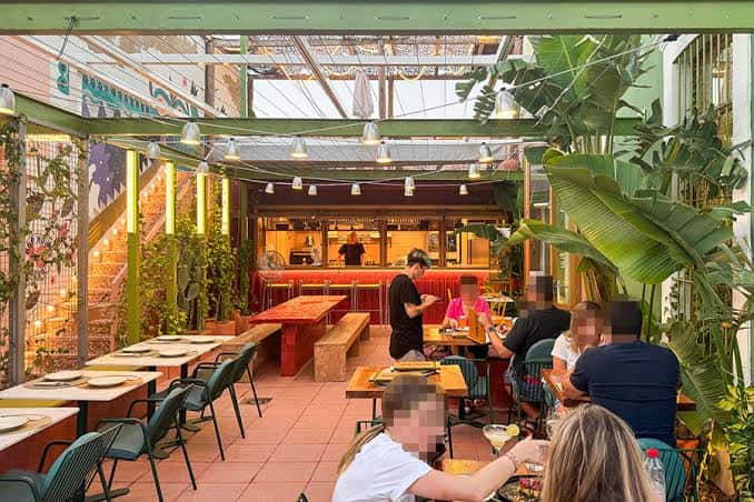 Interior del restaurante con clientes comiendo en ambiente acogedor
