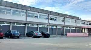 Fachada principal del complejo deportivo con aparcamiento