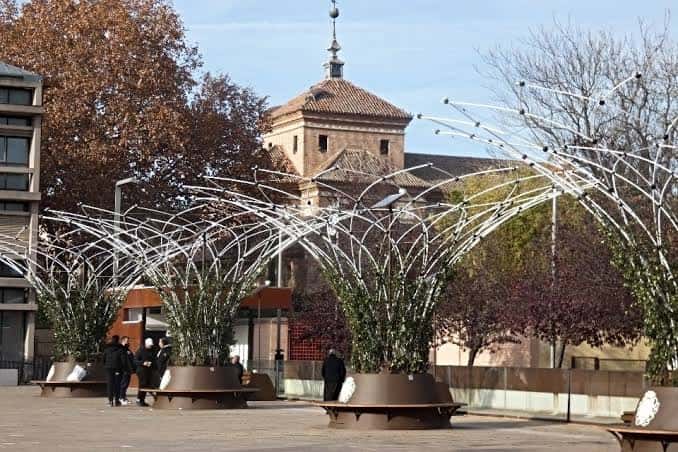 Detalle de los refugios climáticos y la torre de la iglesia en la plaza