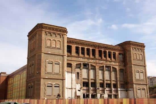 Vista exterior de la Fàbrica Nova en Manresa con fachada industrial y cielo azul