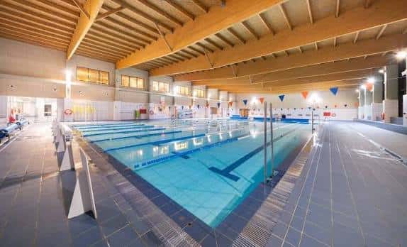 Piscina interior de Forus Fuenlabrada con carriles y techo de vigas de madera