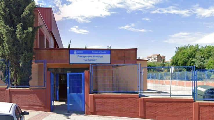 Vista exterior del Polideportivo Municipal La Cueva con su fachada de ladrillo y señalización municipal