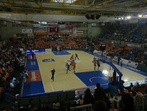 Interior del pabellón deportivo durante un partido de baloncesto con espectadores