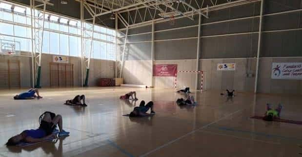 Vista general del interior del pabellón con personas realizando ejercicios en el suelo