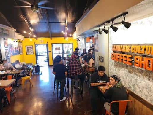 Interior del establecimiento LazyDaze con clientes sentados en mesas y sillas