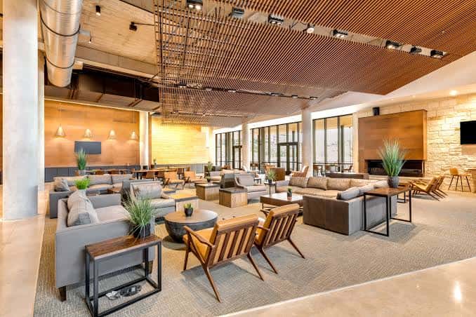 Área de lounge interior con mobiliario moderno y techos de madera
