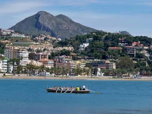 Vista panorámica del Monte San Antón desde el mar con embarcación en primer plano