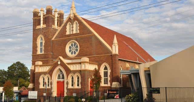 Fachada principal de la iglesia bajo un cielo parcialmente nublado