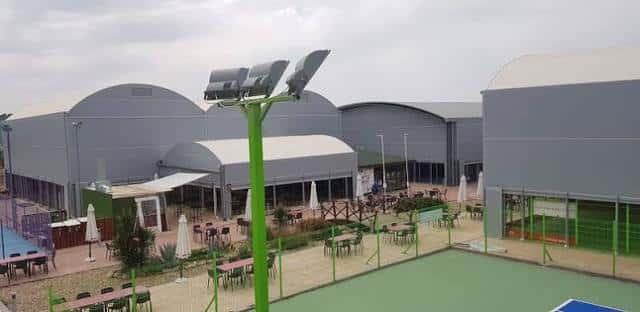 Vista exterior del complejo deportivo con pistas de pádel y zona de terrazas