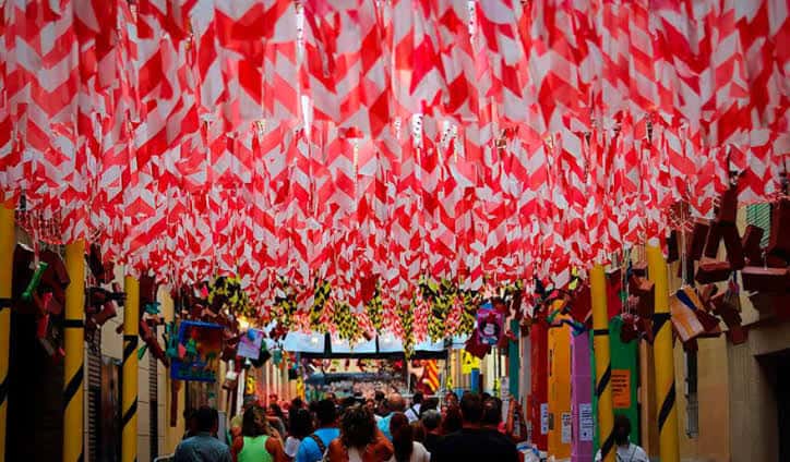 Calle cubierta por banderas rojas y blancas cruzadas típicas de las fiestas
