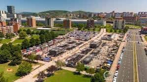 Vista aérea del Recinto Ferial de Ansio con puestos y edificios urbanos al fondo