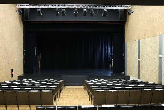 Escenario principal con cortinas negras y sistema de iluminación profesional
