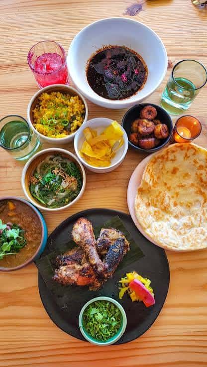 Mesa servida con variedad de platos caribeños y bebidas coloridas
