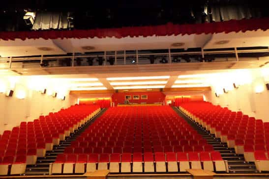 Interior del teatro con gradas rojas y balcón superior