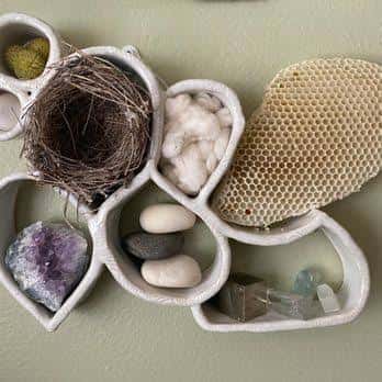 Detalle de una pieza decorativa de cerámica con formas orgánicas y elementos naturales como nido y cristales