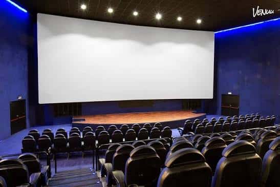 Sala de eventos con pantalla grande y escenario elevado