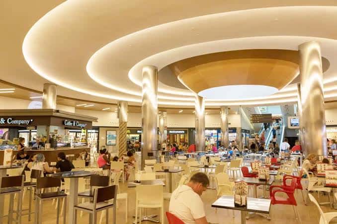 Interior del centro comercial mostrando la zona de restauración y el diseño arquitectónico