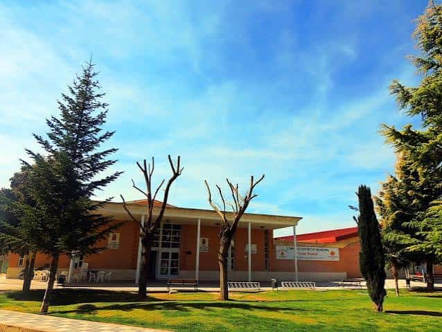 Vista exterior del Complejo Polideportivo Luis Ocaña con fachada de ladrillo y jardines